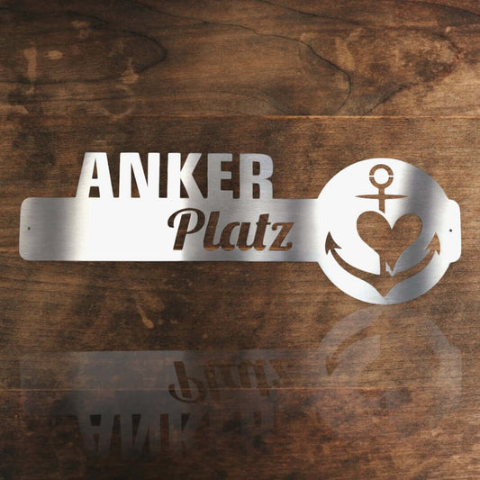 maritime edelstahl wanddeko ankerplatz vor einer holzwand